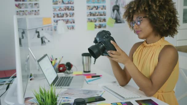 Молодая женщина рассматривает фотографии на камеру — стоковое видео