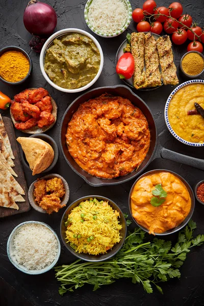Verschiedene indische Gerichte auf einem Tisch. Würzige Huhn Tikka Masala in eiserner Pfanne — Stockfoto