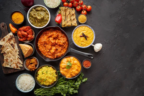 Composition of Indian cuisine in ceramic bowls on black stone table — Stock Photo, Image
