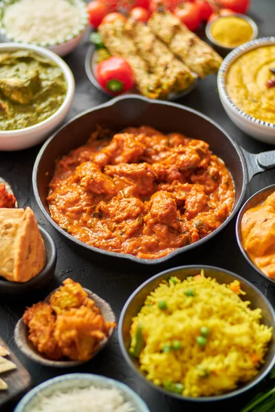 Vários pratos índios em uma mesa. Frango picante Tikka Masala na panela de ferro — Fotografia de Stock