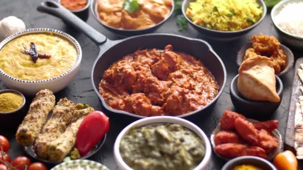 Various Indian dishes on a table. Spicy chicken Tikka Masala in iron pan — Stock Video