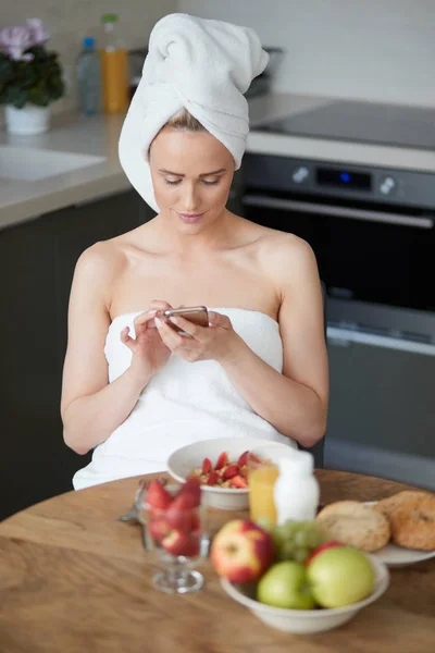 Belle femme avec serviette sur la tête ayant un petit déjeuner sain et café — Photo