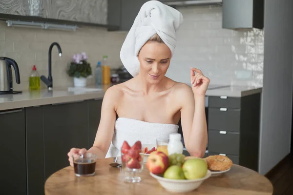 Schöne Frau mittleren Alters sitzt in ihrer Küche am Morgen — Stockfoto