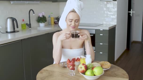 美丽的妇女与毛巾在头上有一个健康的早餐和咖啡 — 图库视频影像