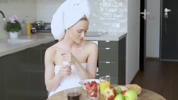 Hermosa mujer de mediana edad sentada en su cocina por la mañana — Vídeos de Stock