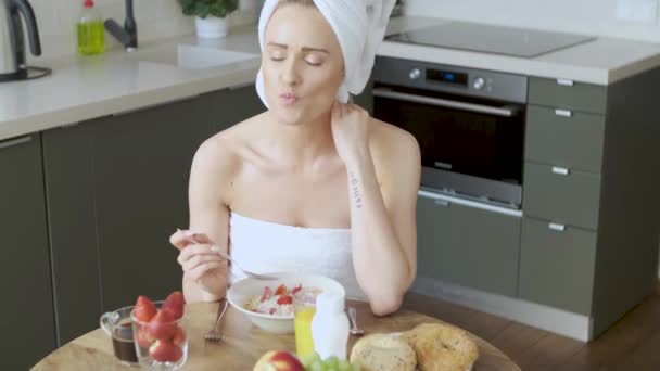 Όμορφη μέσης ηλικίας γυναίκα που κάθεται στην κουζίνα της το πρωί — Αρχείο Βίντεο