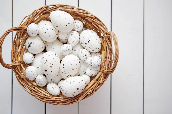Korg av vita prickade påsk ägg i brun flätad korg — Stockfoto