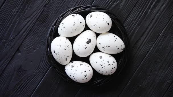 Bütün tavuk yumurta siyah bir rustik ahşap zemin üzerine bir yuvada. Paskalya sembolleri — Stok video