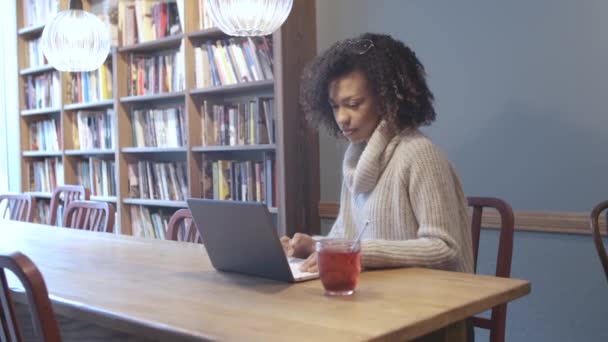 Alkalmi diák nő ül kávézóban és használata laptop — Stock videók