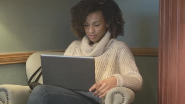 Випадкова студентка сидить у кав'ярні та використовує ноутбук — стокове відео