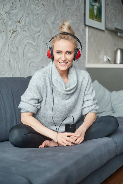 Retrato de mujer atractiva usando un teléfono inteligente para escuchar música — Foto de Stock