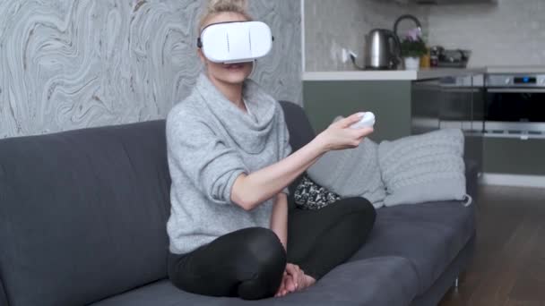 Giovane donna che guarda video o gioca con occhiali VR sulla testa — Video Stock