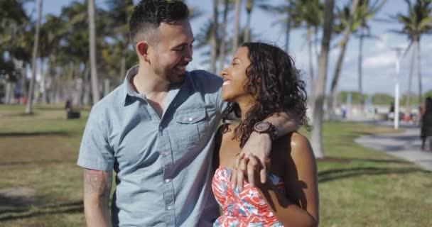 Multi-etnisch paar in zomer park lachen — Stockvideo