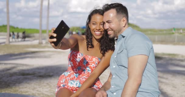 Pareja emocionada tomando selfie en primera línea de mar — Vídeo de stock