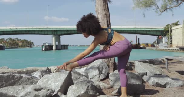 Chica negra haciendo ejercicio en la orilla del río — Vídeo de stock