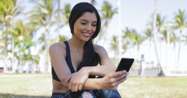 Jolie fille avec téléphone sur l'entraînement dans le parc — Video