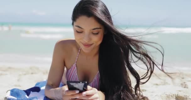 Menina bonita usando telefone na praia — Vídeo de Stock