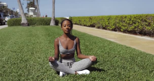 Mujer negra haciendo yoga en el césped — Vídeos de Stock