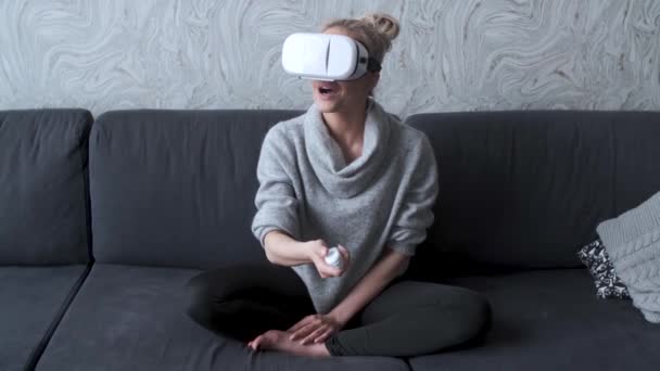 Jeune femme regardant des vidéos ou jouant avec des lunettes VR sur la tête — Video