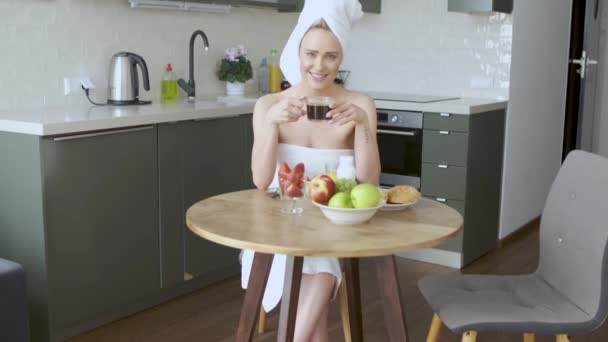 Hermosa mujer con toalla en la cabeza tomando un desayuno saludable y café — Vídeos de Stock