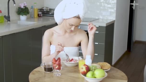 Gyönyörű Közép-éves nő ül az ő konyhában reggel — Stock videók