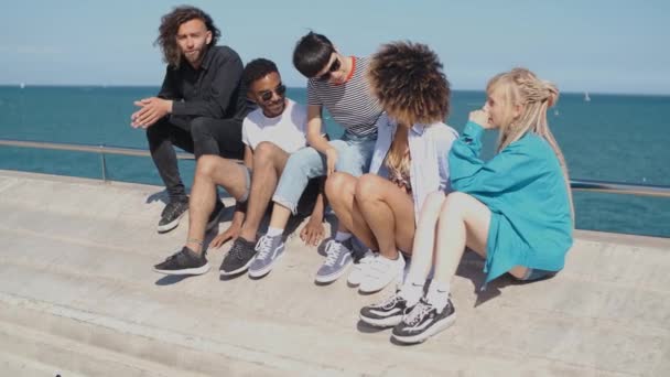 Les jeunes amis branchés se refroidissent en bord de mer — Video