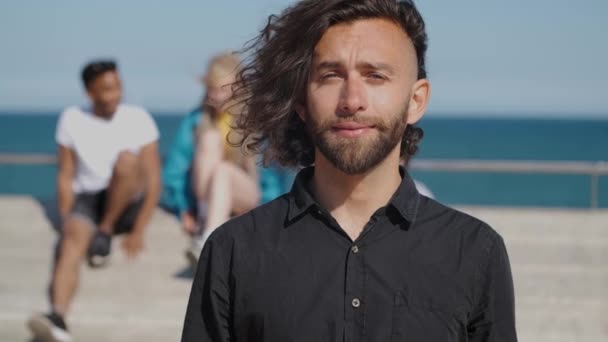 Jonge stijlvolle man in het zonlicht aan de kust — Stockvideo