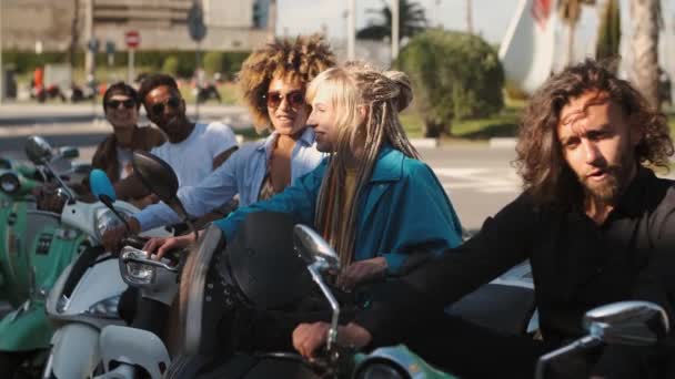 Scooter üzerinde Trendy genç arkadaşlar kamera sallayarak — Stok video