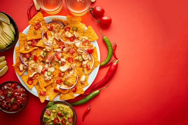 Um prato de deliciosos nachos de tortilla com molho de queijo derretido, frango grelhado — Fotografia de Stock