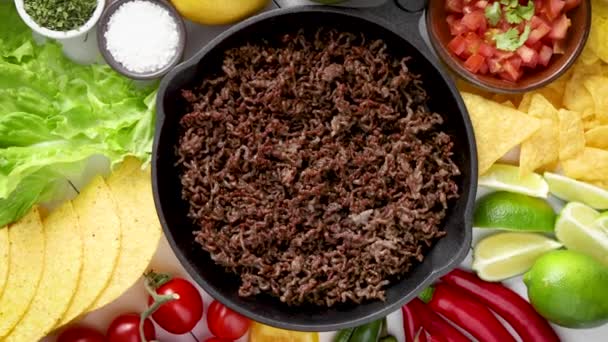 Ingredients for Chili con carne in frying iron pan on white wooden table — Stock Video