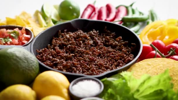 Ingredientes para Chili con carne en sartén de hierro sobre mesa de madera blanca — Vídeos de Stock