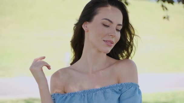 Rozkošná brunetka relaxační v parku nebo na louce v zelené letní scenérii — Stock video