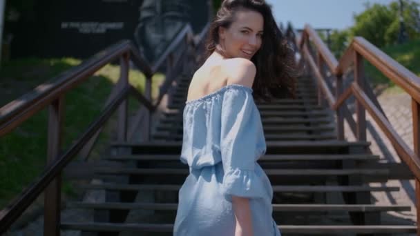 Vacker kvinna i sommar mode klänning gå på trappor i mitten av staden — Stockvideo