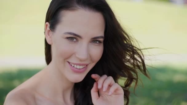 Mulher bonita, modelo de moda com cabelo castanho longo sentado na grama verde — Vídeo de Stock