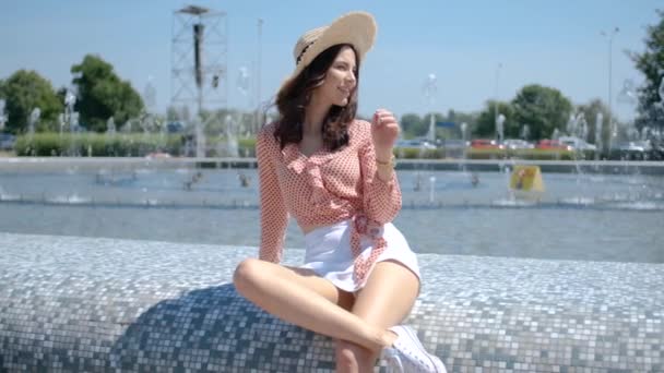 Mooie vrouw poseren naast de fontein van de stad in de zomertijd — Stockvideo