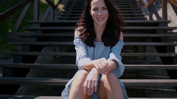 Mulher morena adorável sentada nas escadas ao ar livre — Vídeo de Stock