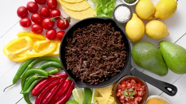 Ingredientes para Chili con carne en sartén de hierro sobre mesa de madera blanca — Vídeos de Stock