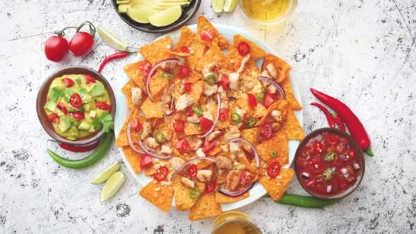 A plate of delicious tortilla nachos with melted cheese sauce, grilled chicken — Stock Video