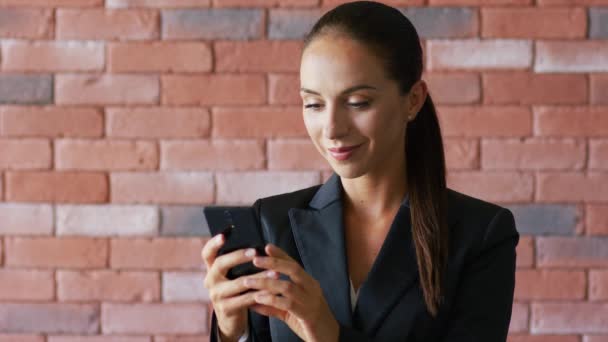 Femme d'affaires souriante avec queue de cheval en utilisant un smartphone — Video