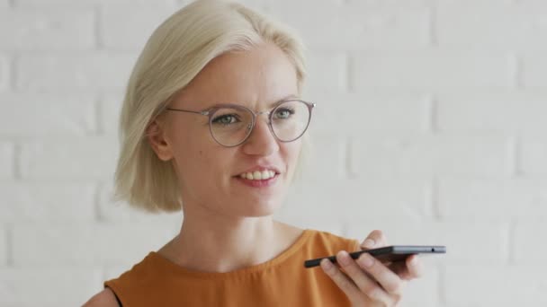 Frau mit kurzen Haaren nimmt Audiobotschaft auf — Stockvideo