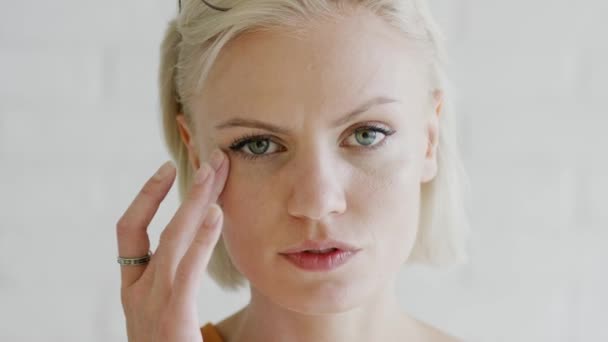 Woman with short hair applying cream — Stock Video