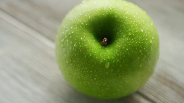 Зеленое спелое яблоко с каплями воды — стоковое видео