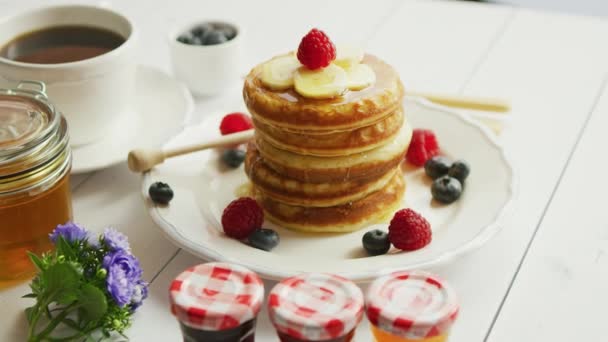 Pancakes with slices of banana and berries — Stock Video