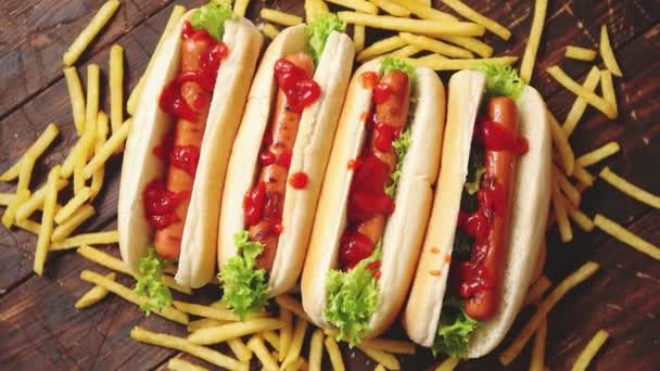 Amerykańskie hot dogi posortowane w rzędzie. Podawany z frytkami — Wideo stockowe