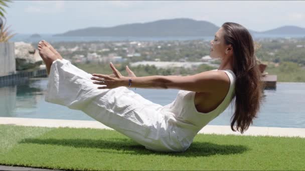 Calma turista praticare yoga in equilibrio asana a bordo piscina contro città sulla costa — Video Stock
