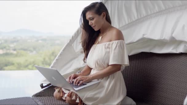 Terasta dizüstü bilgisayarı güzel manzaraya karşı kullanan rahat bir kadın. — Stok video