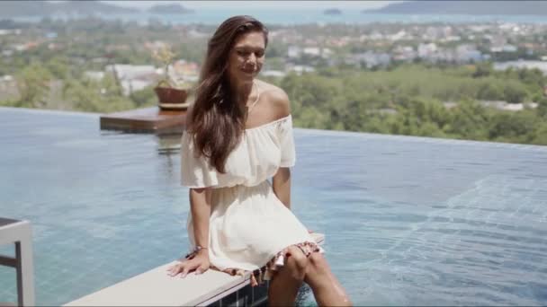 Mujer atractiva divirtiéndose mientras descansa junto a la piscina en el hotel — Vídeos de Stock
