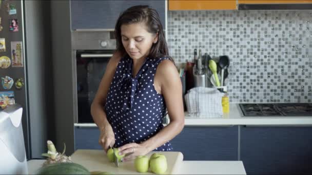 Mujer cortando manzanas a bordo en la cocina — Vídeos de Stock