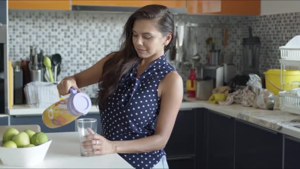 Kvinnan häller saft från kanna till glas — Stockvideo