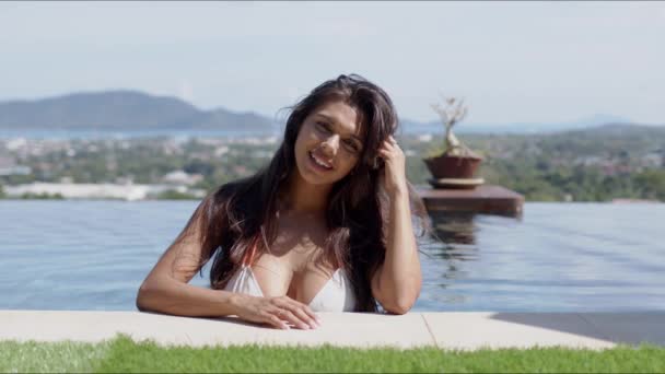 Güzel bir kadın havuzda güneşli bir günün tadını çıkarıyor — Stok video